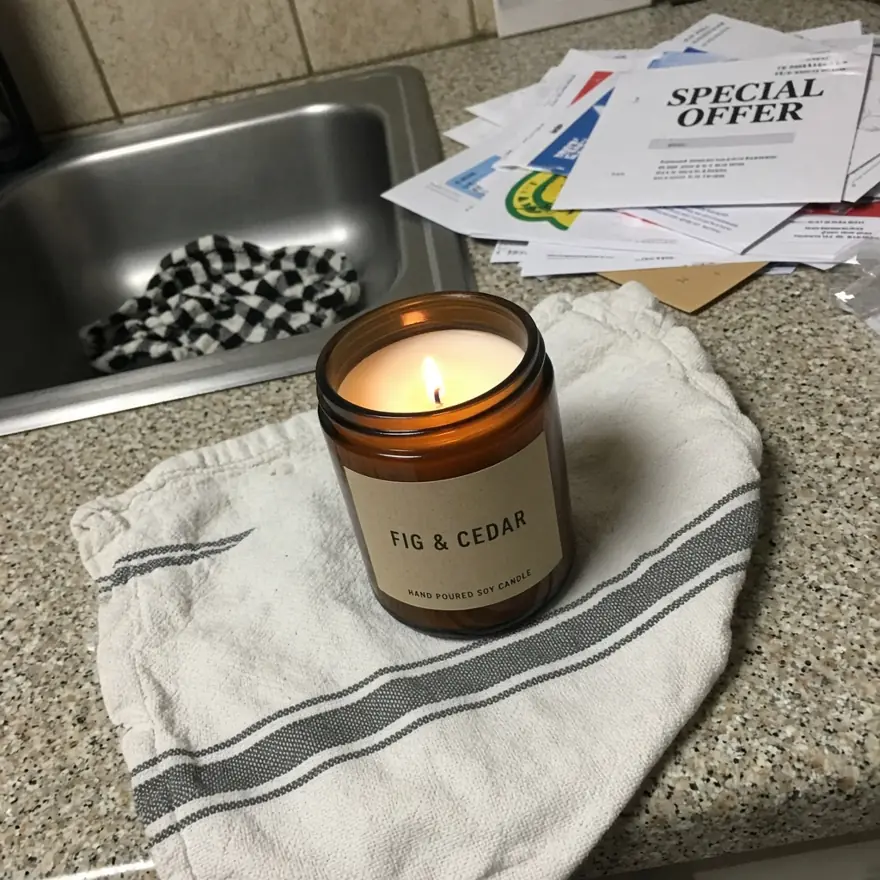 Before: the same candle photographed on a cluttered kitchen counter