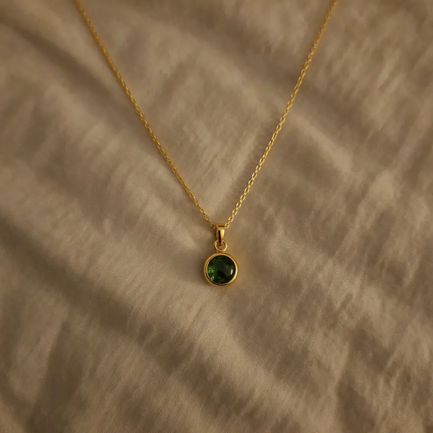 Before: necklace on a wrinkled bedsheet